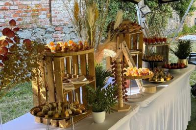Buffet avec des amuse-bouches variés présentés sur des plateaux en bois et des verrines en arrière-plan.