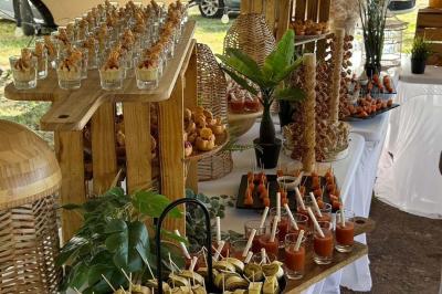 Buffet avec des amuse-bouches variés présentés sur des plateaux en bois et des verrines en arrière-plan.