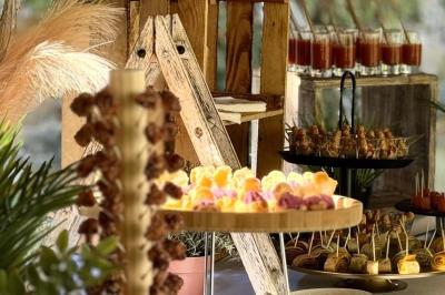 Buffet avec des amuse-bouches variés présentés sur des plateaux en bois et des verrines en arrière-plan.