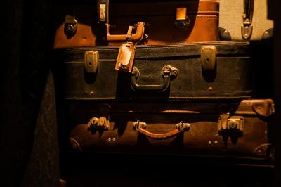 Deux statuettes africaines en gros plan, éclairées par des bougies en arrière-plan dans une ambiance tamisée.