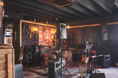 Deux statuettes africaines en gros plan, éclairées par des bougies en arrière-plan dans une ambiance tamisée.