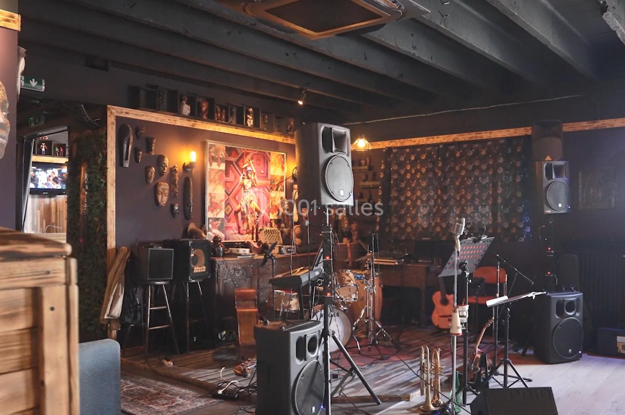 Salle de musique décorée avec des instruments, des enceintes, des œuvres d'art et un éclairage tamisé.