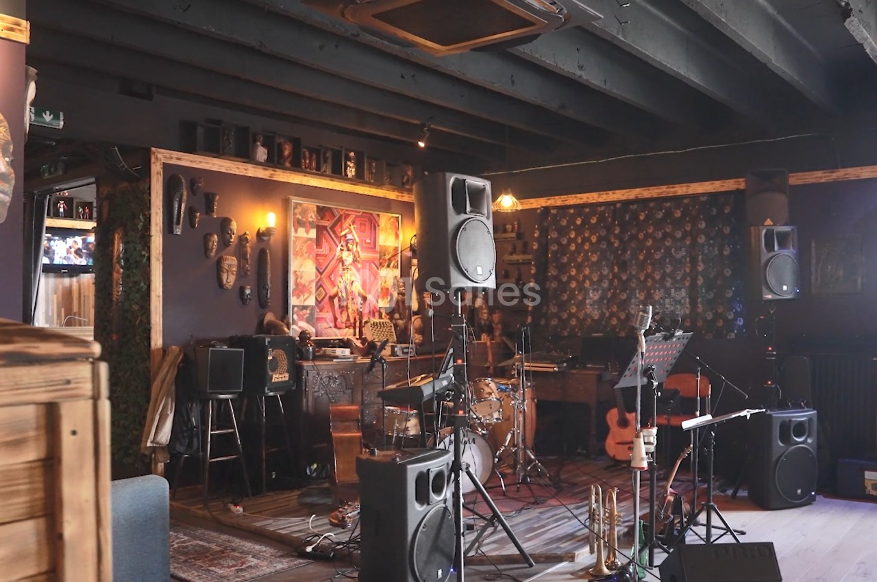 Salle de musique décorée avec des instruments, des enceintes, des œuvres d'art et un éclairage tamisé.