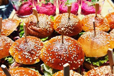 Plateau de mini-burgers au pain brioché, garnis de viande et de légumes colorés.