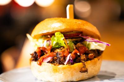 Plateau de mini-burgers au pain brioché, garnis de viande et de légumes colorés.