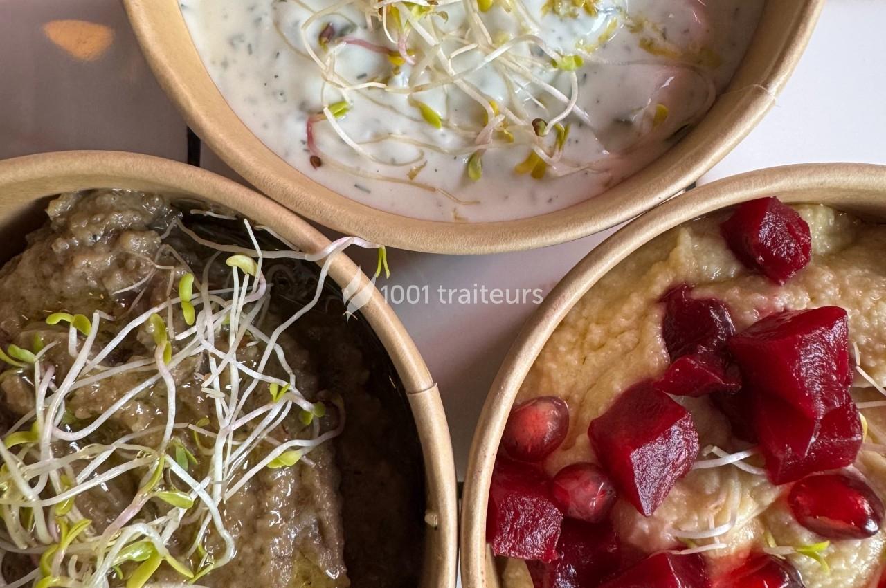 Trois bols de mezzés : caviar d’aubergine, tzatziki avec pousses, et houmous garni de betterave et grenade.