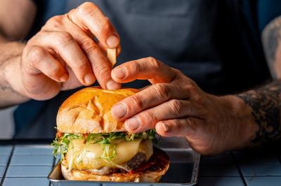 Plateau de mini-burgers au pain brioché, garnis de viande et de légumes colorés.