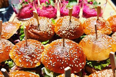 Plateau de mini-burgers au pain brioché, garnis de viande et de légumes colorés.