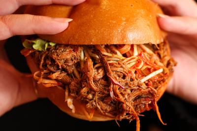 Plateau de mini-burgers au pain brioché, garnis de viande et de légumes colorés.