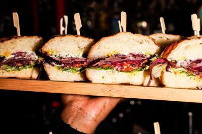 Plateau de mini-burgers au pain brioché, garnis de viande et de légumes colorés.