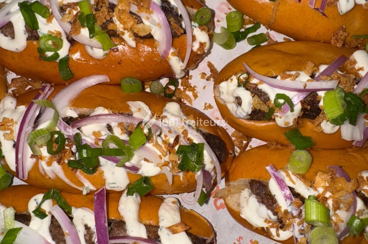 Petits pains garnis de viande hachée, oignons rouges, oignons verts, sauce blanche et oignons frits.