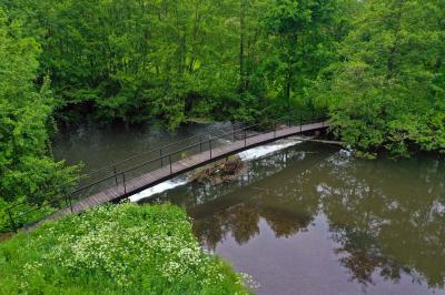 Salle de réception décorée avec des tables rondes dressées, nappes blanches, verres et couverts élégants.
