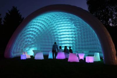 Salle de réception décorée avec des tables rondes dressées, nappes blanches, verres et couverts élégants.