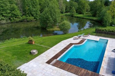 Salle de réception décorée avec des tables rondes dressées, nappes blanches, verres et couverts élégants.