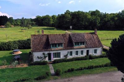 Salle de réception décorée avec des tables rondes dressées, nappes blanches, verres et couverts élégants.