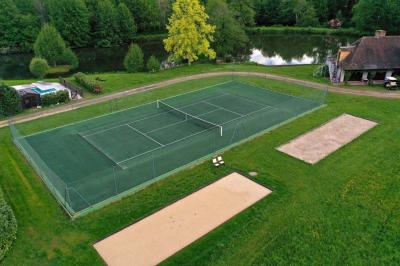 Salle de réception décorée avec des tables rondes dressées, nappes blanches, verres et couverts élégants.