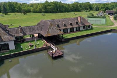 Salle de réception décorée avec des tables rondes dressées, nappes blanches, verres et couverts élégants.