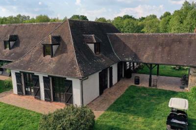 Salle de réception décorée avec des tables rondes dressées, nappes blanches, verres et couverts élégants.