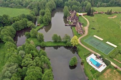 Salle de réception décorée avec des tables rondes dressées, nappes blanches, verres et couverts élégants.