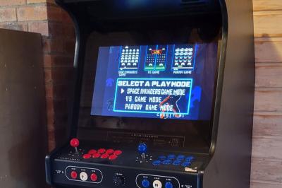Salle de réception décorée avec des tables rondes dressées, nappes blanches, verres et couverts élégants.
