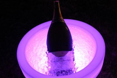 Salle de réception décorée avec des tables rondes dressées, nappes blanches, verres et couverts élégants.