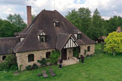 Salle de réception décorée avec des tables rondes dressées, nappes blanches, verres et couverts élégants.