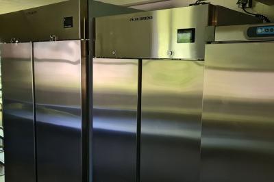 Salle de réception décorée avec des tables rondes dressées, nappes blanches, verres et couverts élégants.