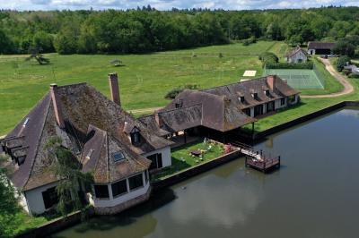 Salle de réception décorée avec des tables rondes dressées, nappes blanches, verres et couverts élégants.