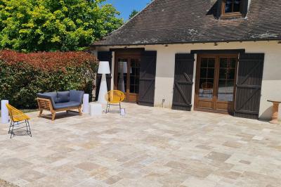 Salle de réception décorée avec des tables rondes dressées, nappes blanches, verres et couverts élégants.