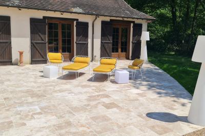 Salle de réception décorée avec des tables rondes dressées, nappes blanches, verres et couverts élégants.