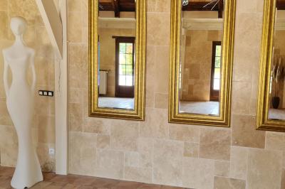Salle de réception décorée avec des tables rondes dressées, nappes blanches, verres et couverts élégants.