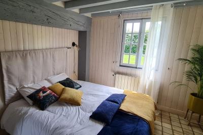Salle de réception décorée avec des tables rondes dressées, nappes blanches, verres et couverts élégants.