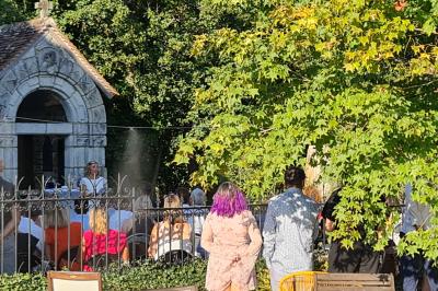 Salle de réception décorée avec des tables rondes dressées, nappes blanches, verres et couverts élégants.