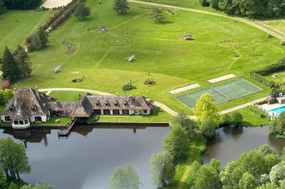 Salle de réception décorée avec des tables rondes dressées, nappes blanches, verres et couverts élégants.