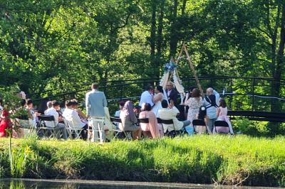 Salle de réception décorée avec des tables rondes dressées, nappes blanches, verres et couverts élégants.