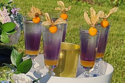 Salle de réception décorée avec des tables rondes dressées, nappes blanches, verres et couverts élégants.