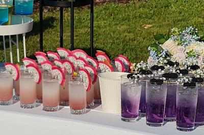 Salle de réception décorée avec des tables rondes dressées, nappes blanches, verres et couverts élégants.