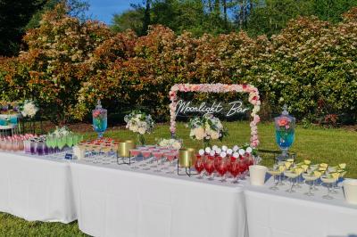 Salle de réception décorée avec des tables rondes dressées, nappes blanches, verres et couverts élégants.