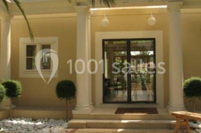 Groupe de personnes dînant en plein air sur une terrasse avec vue sur un paysage verdoyant et des collines au coucher du…
