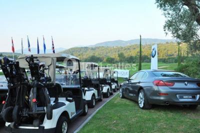 Groupe de personnes dînant en plein air sur une terrasse avec vue sur un paysage verdoyant et des collines au coucher du…