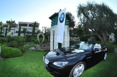 Groupe de personnes dînant en plein air sur une terrasse avec vue sur un paysage verdoyant et des collines au coucher du…