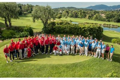 Groupe de personnes dînant en plein air sur une terrasse avec vue sur un paysage verdoyant et des collines au coucher du…
