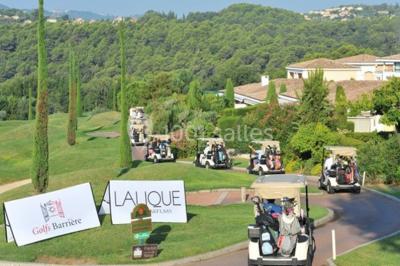 Groupe de personnes dînant en plein air sur une terrasse avec vue sur un paysage verdoyant et des collines au coucher du…