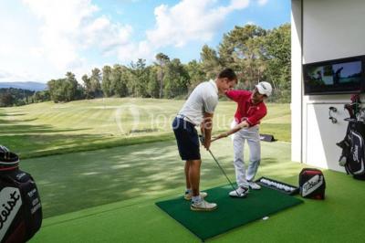 Groupe de personnes dînant en plein air sur une terrasse avec vue sur un paysage verdoyant et des collines au coucher du…