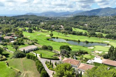 Groupe de personnes dînant en plein air sur une terrasse avec vue sur un paysage verdoyant et des collines au coucher du…