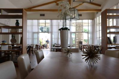 Groupe de personnes dînant en plein air sur une terrasse avec vue sur un paysage verdoyant et des collines au coucher du…