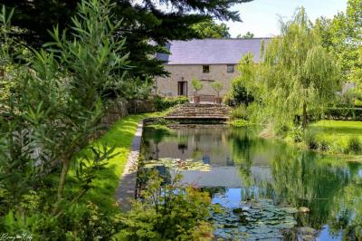 Table élégamment dressée avec chandeliers noirs, verres en cristal et nappes blanches dans une salle au style rustique.