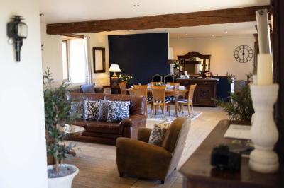 Table élégamment dressée avec chandeliers noirs, verres en cristal et nappes blanches dans une salle au style rustique.
