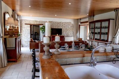 Table élégamment dressée avec chandeliers noirs, verres en cristal et nappes blanches dans une salle au style rustique.