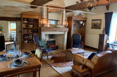 Table élégamment dressée avec chandeliers noirs, verres en cristal et nappes blanches dans une salle au style rustique.